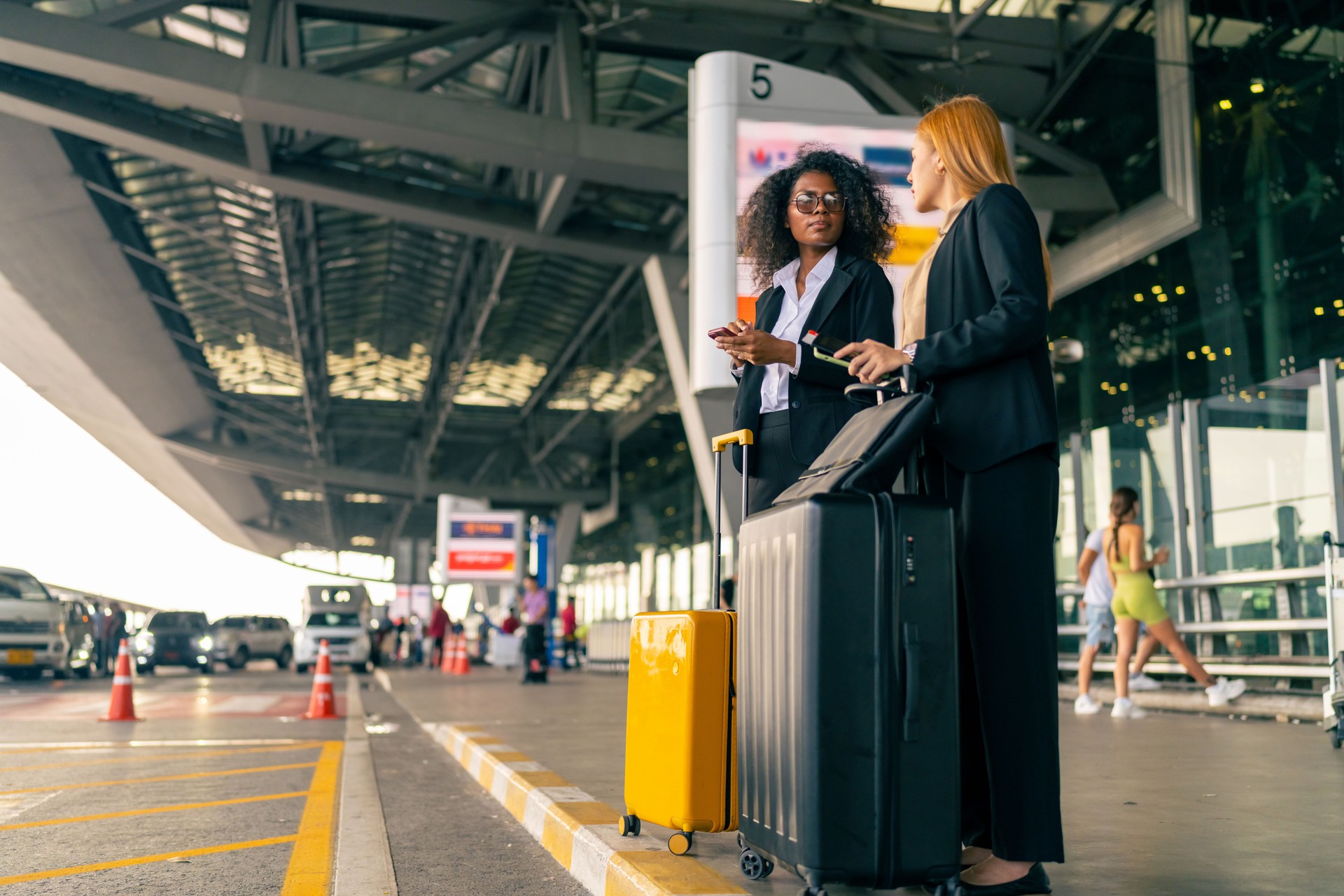 Two Businesswoman waiting for taxi at airport terminal.